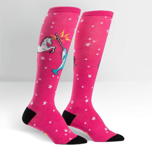 A pink knee high sock with a unicorn and a narwal fighting. Their horns clash, emitting a yellow spark. The sock has white stars all over, and black heel and toes - The Sockery
