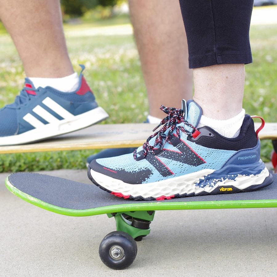 Person wearing sneakers and white loose fit no show socks while riding a skate board - The Sockery