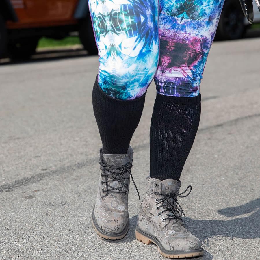 Woman waring black loose fit over the calf socks over colourful leggings, front view - The Sockery