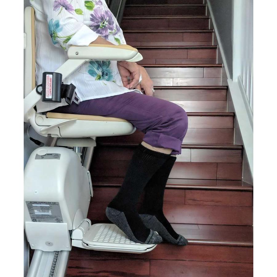 Woman using a stair lift wearing black extra wide socks - The Sockery