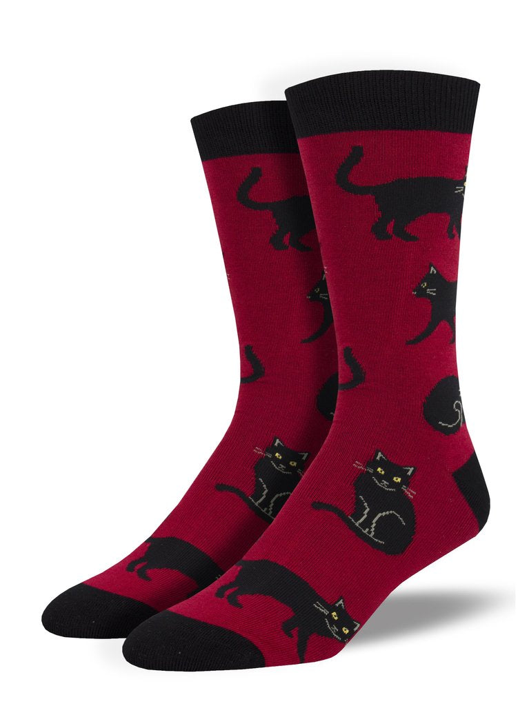 A deep red mens bamboo crew sock with a design with black cats, sitting walking and sleeping